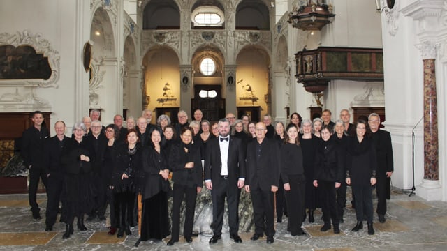 Eine Gruppe Menschen in schwarz gekleidet in einer Kirche.