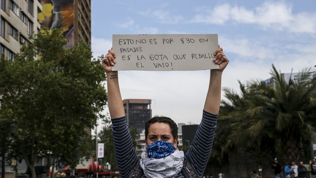 Eine Demonstrantin mit einem Karton-Schild