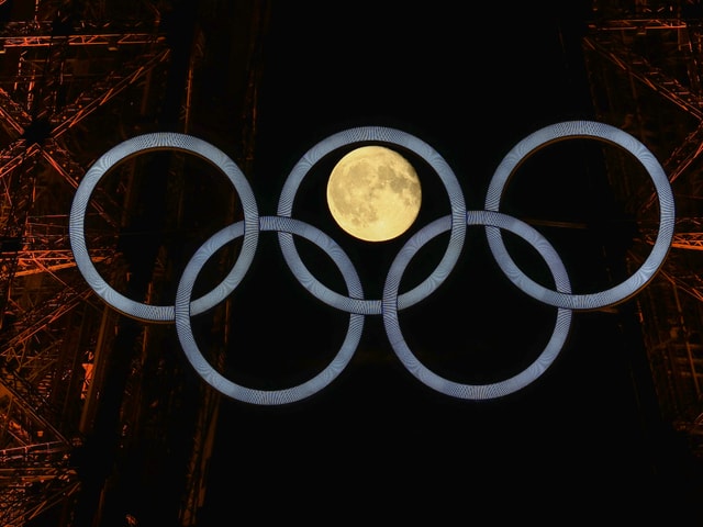 Der Mond hinter den Olympischen Ringen.