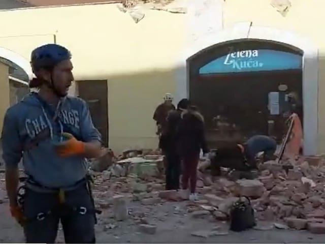 Helpers in the streets of Petrinja, rubble and rubble lie on the ground.