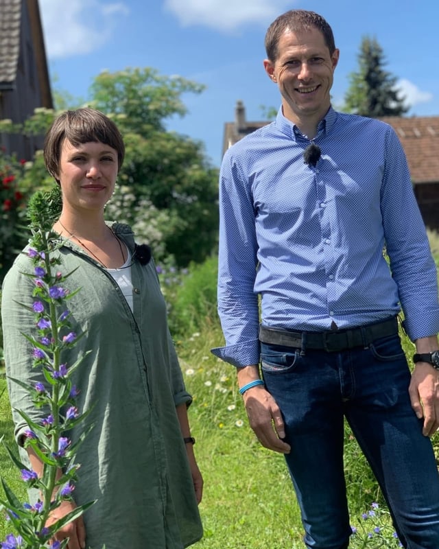 Frau und Mann stehen in einem blühenden Garten