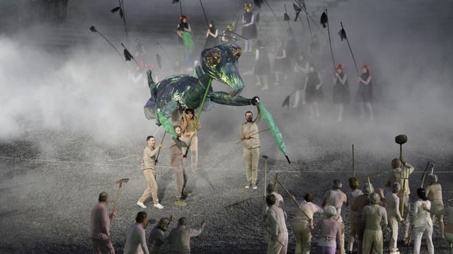 Theateraufführung mit riesiger Mantis-Puppe und Performern.