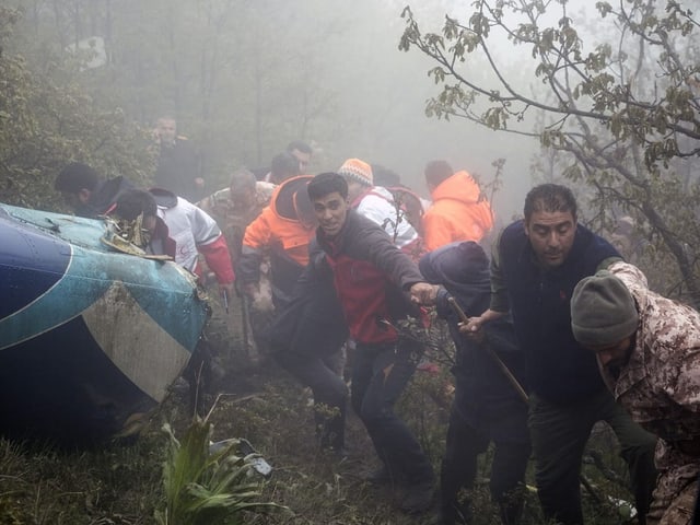 Menschen helfen bei der Rettung nach einem Hubschrauberabsturz im Wald.