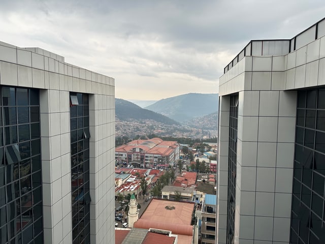 Zwei grosse Hochhäuser. Im Hintergrund sieht man die Stadt und Hügeln. 