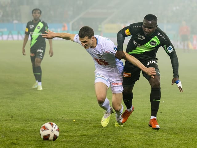 Zwei Fussballspieler, einer vom FCL, einer von St. Gallen, kämpfen um den Ball.