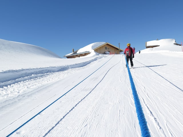 Schlepplift im Skigebiet zieht Mann hinauf. 