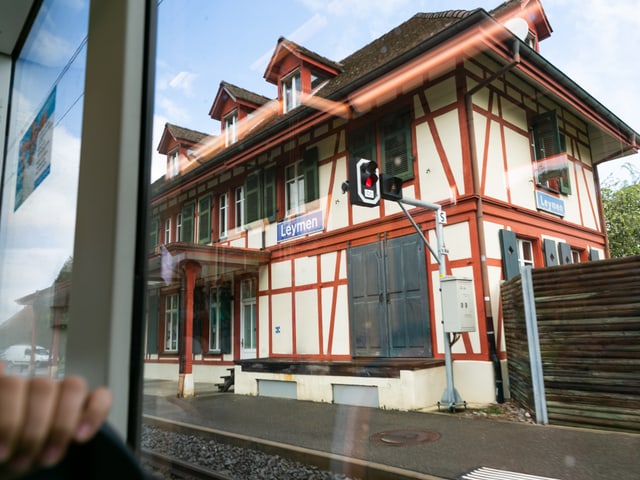 Aus dem Tramfenster sieht man ein Haus, das mit «Leymen» angeschrieben ist.