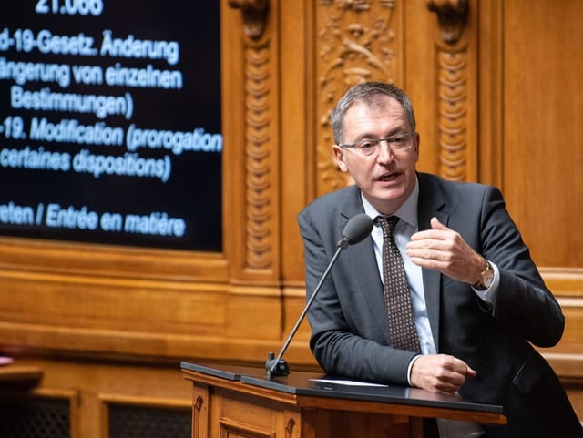 Roland Buechel sitzt am Rednerpult im Nationalratsaal und spricht.