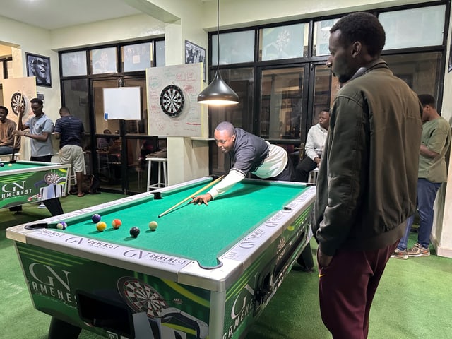 Menschen spielen in einer Halle Billiard. 