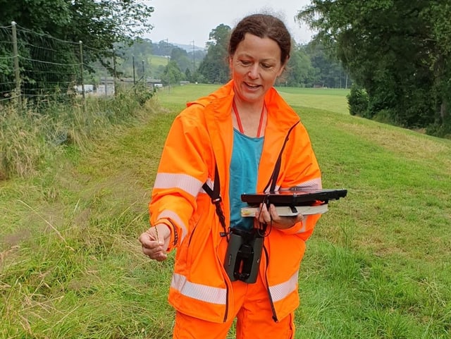 Biologin hält Gras und Tablet in der Hand