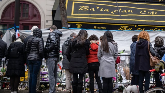 Menschen stehen vor dem Konzertsaal Bataclan, wo Blumen niedergelgt wurden.