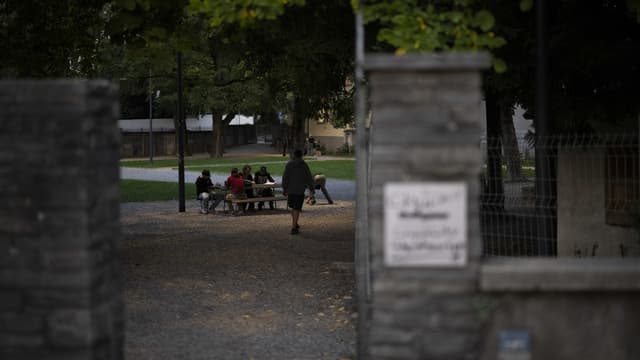 Gemäuer, dahinter Menschen an einem Tisch