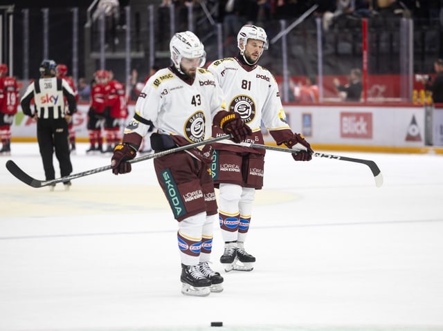 Zwei Eishockeyspieler in weissen Trikots auf dem Eis.