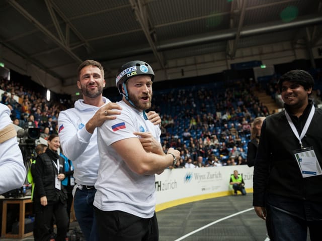 Zwei Teilnehmer des Cybathlon feiern ein gelungenes Rennen.