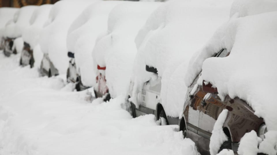 Parkierte und vom Schnee bedeckte Autos in Basel.