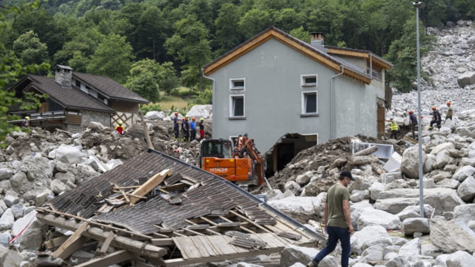Rettungskräfte inspizieren am Dienstag in der Gemeinde Sorte im südschweizerischen Lostallo die Stelle eines Erdrutsches, der durch Unwetter und starke Regenfälle im Misox-Tal verursacht wurde.