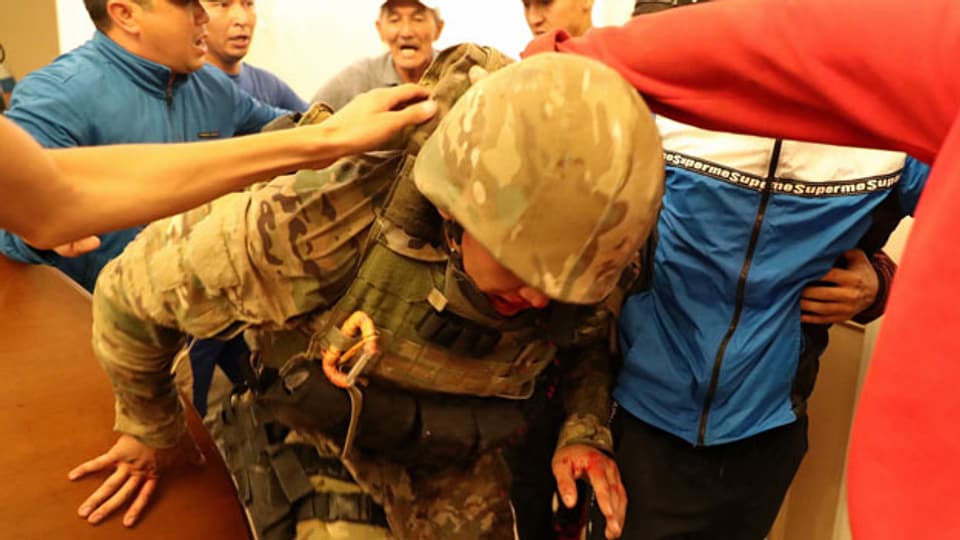 Ein Mitglied der GKNB-Sondereinheiten wird von Anhängern des ehemaligen kirgisischen Präsidenten verhaftet.