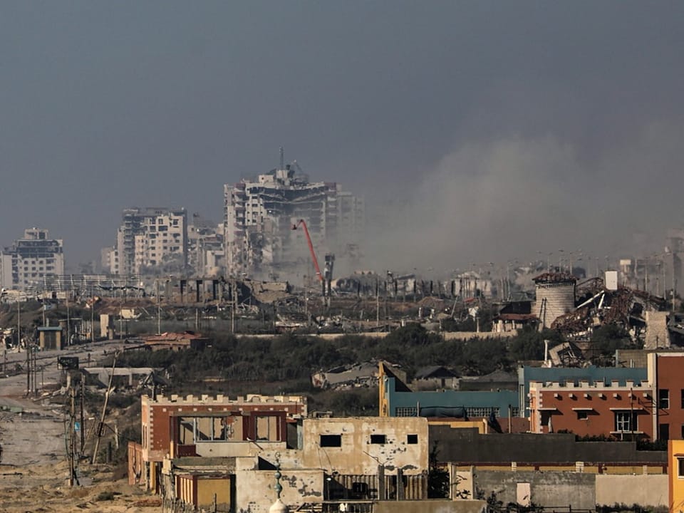 Grosse zerstörte Wohnhäuser und zerstörte Gebäude, aus denen Rauch aufsteigt