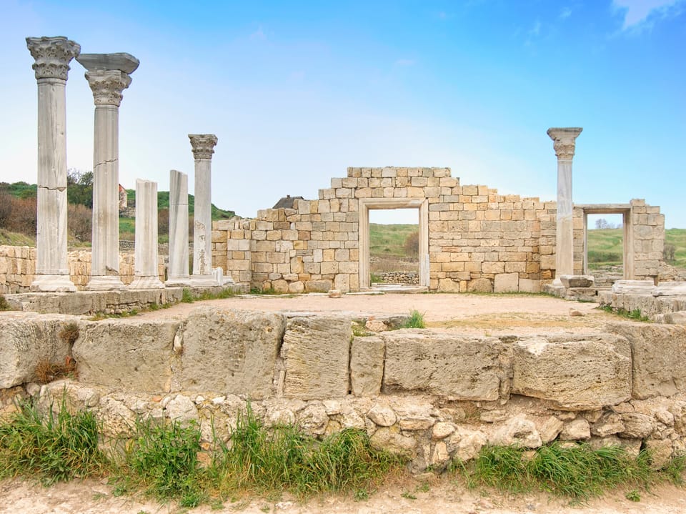 Ruinen einer antiken Stadt mit steinernen Säulen und Wänden.