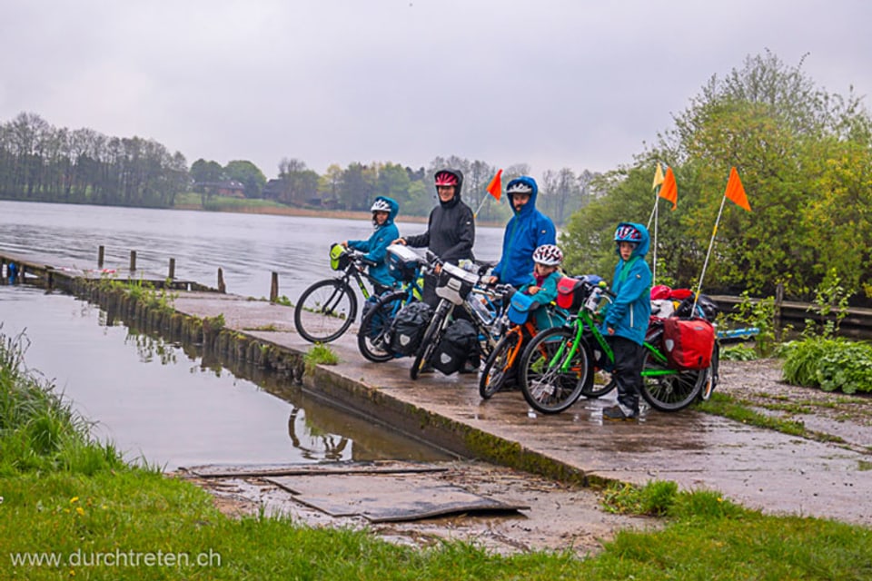 Familie mit Velos im Regen