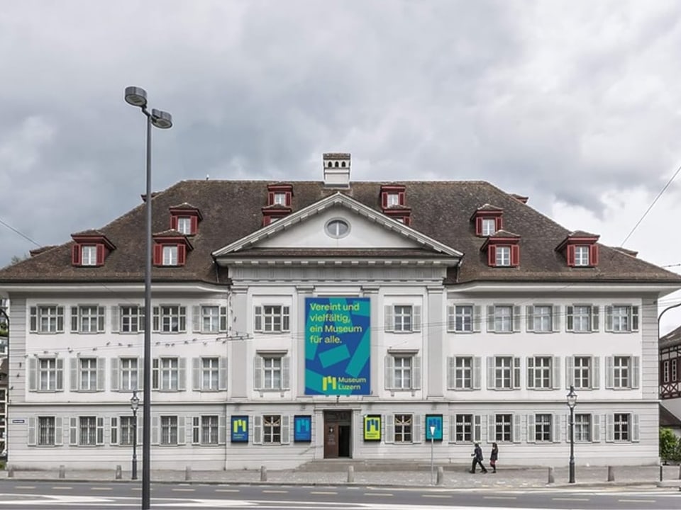 Ein grosses, herrschaftliches Gebäude mit weisser Fassade und Ziegeldach.