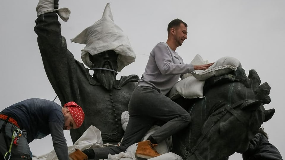Freiwillige versuchen, ein Monument im Zentrum von Kiew einzupacken, um es zu schützen. 26.3.2022