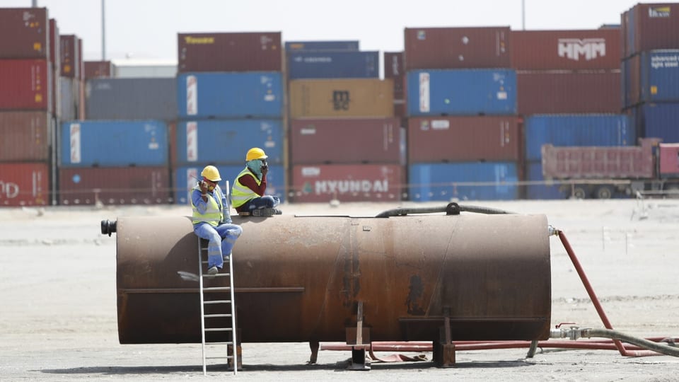 Arbeiter sitzen vor Schiffscontainern auf dem Dock im Seehafen von Berbera in Somaliland.