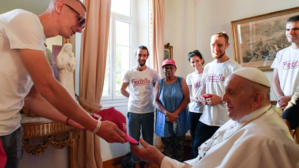 Eine Gruppe junger Menschen übergibt dem Papst bei einer Audienz ein Geschenk.