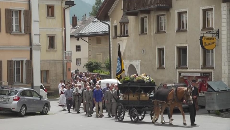 Traditioneller Umzug mit Pferdewagen durch eine Dorfgasse.