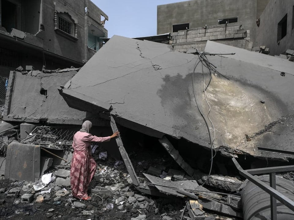 Frau in einem zerstörten Gebäude nach einem Bombenangriff.