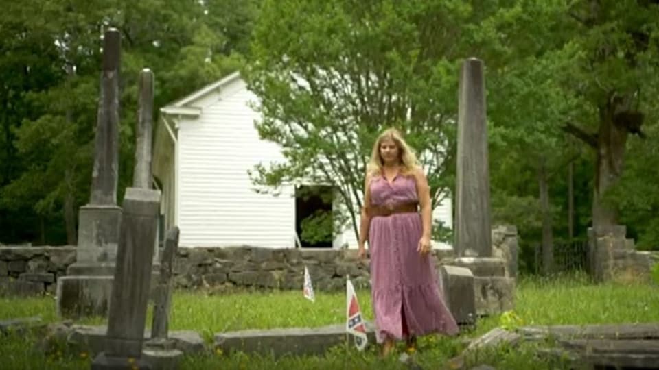 Eine Frau auf dem Friedhof gehend