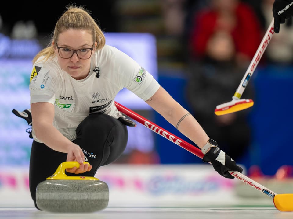 Frau beim Curling, beugt sich vor, hält Besen und Stein.