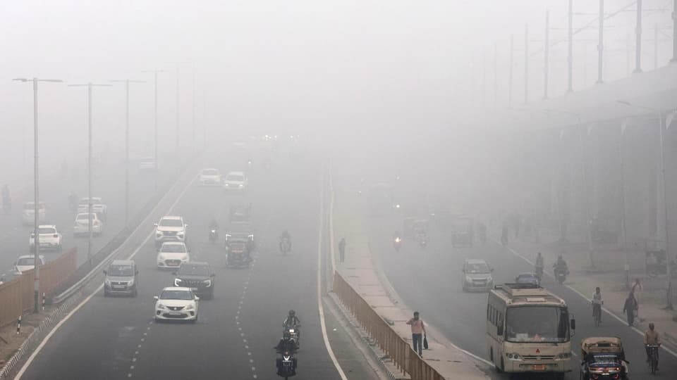 Eine Strasse in Neu-Delhi im Smog