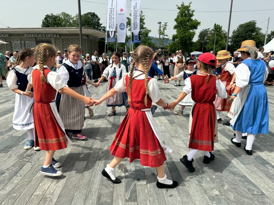 Eine Gruppe Mädchen tanzt in Trachten 