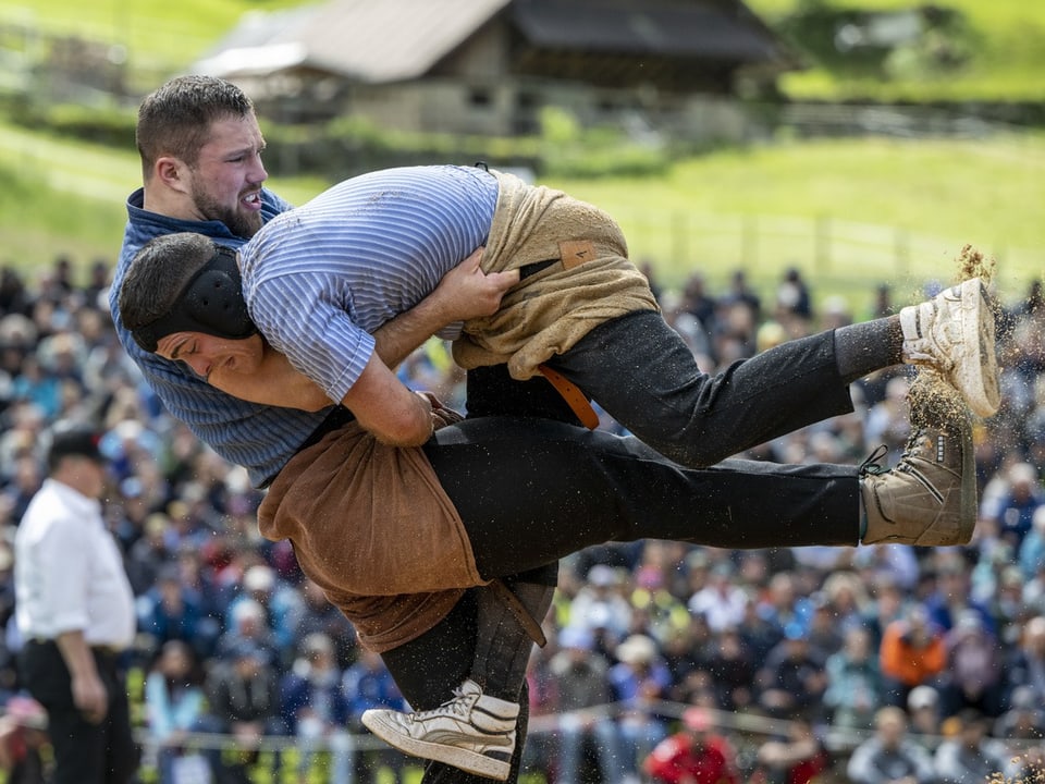 Zwei Männer beim Schwingen-Wettkampf, Publikum im Hintergrund.