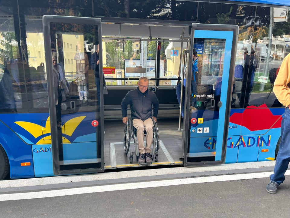 Mann im Rollstuhl verlässt Bus über Rampe.