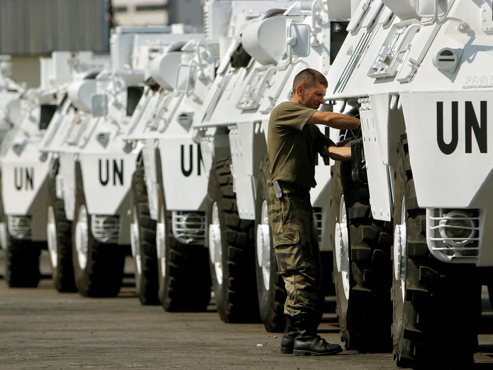 Soldat inspiziert UNO-Fahrzeugreihe.