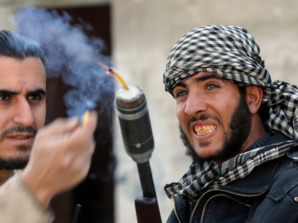 Um eine selbst gebaute Granate abzufeuern, haben zwei Kämpfer der Freien Syrischen Armee eine Schrotflinte umfunktioniert. 