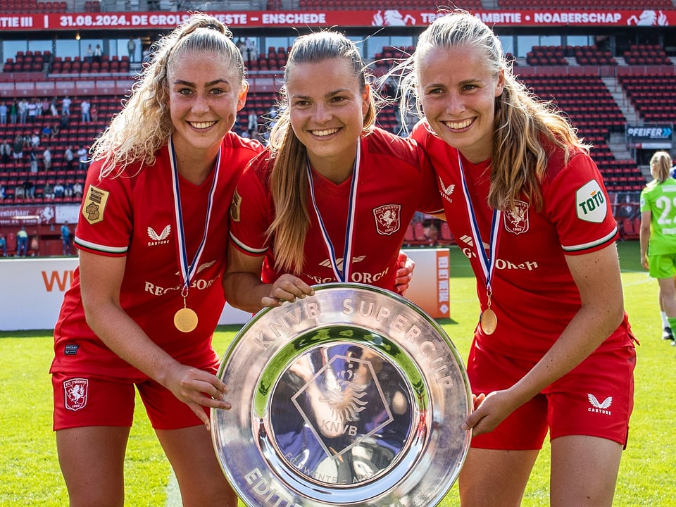 Drei Twente-Spielerinnen mit Supercup-Schale.