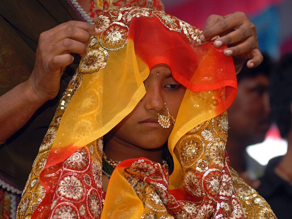 Indische Frau mit traditionellem Schleier in leuchtenden Farben.