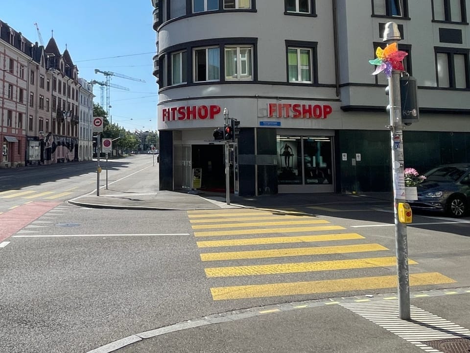 Strassenkreuzung mit einem Fitshop-Geschäft.