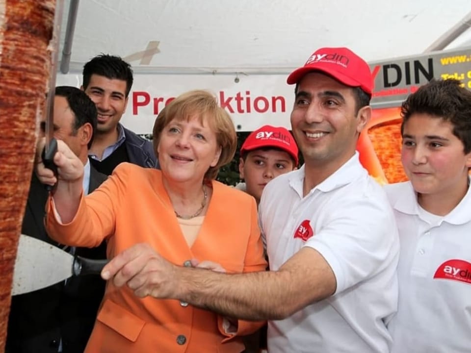 Angela Merkel schneidet Döner an einem Spiess