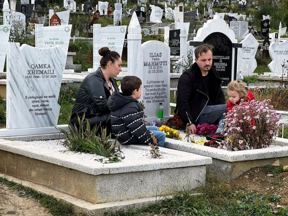 Eine Familie beim Besuch eines Grabes
