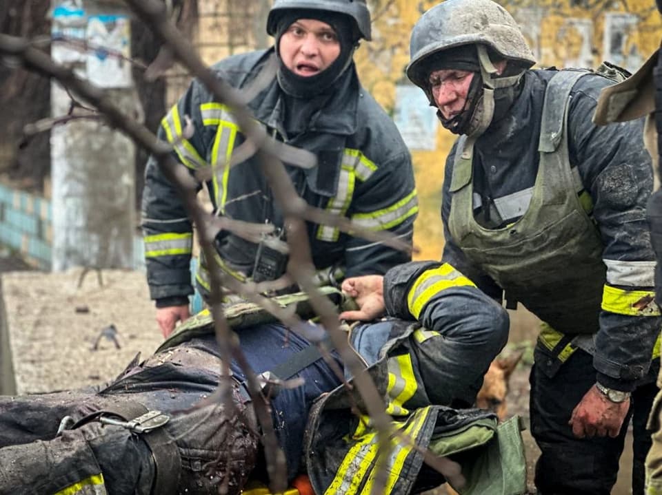 Firefighters in protective suits rescued the injured comrades.