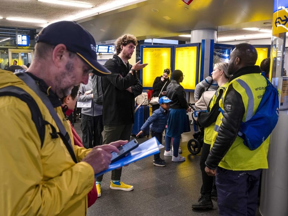 Reisende warten am Hauptbahnhof Amsterdam.