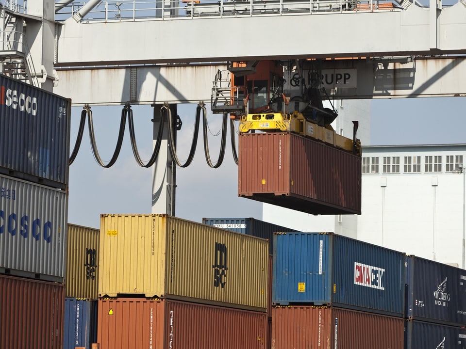 Containerkran hebt eine Frachtbox am Hafen.