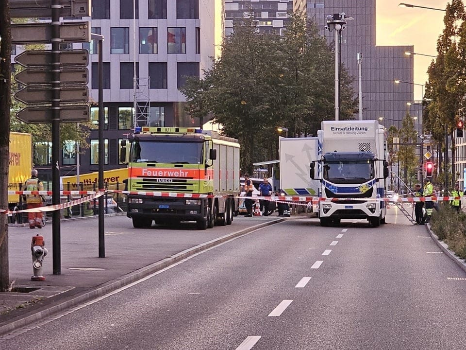 Einsatzfahrzeuge vor abgesperrter Strasse.