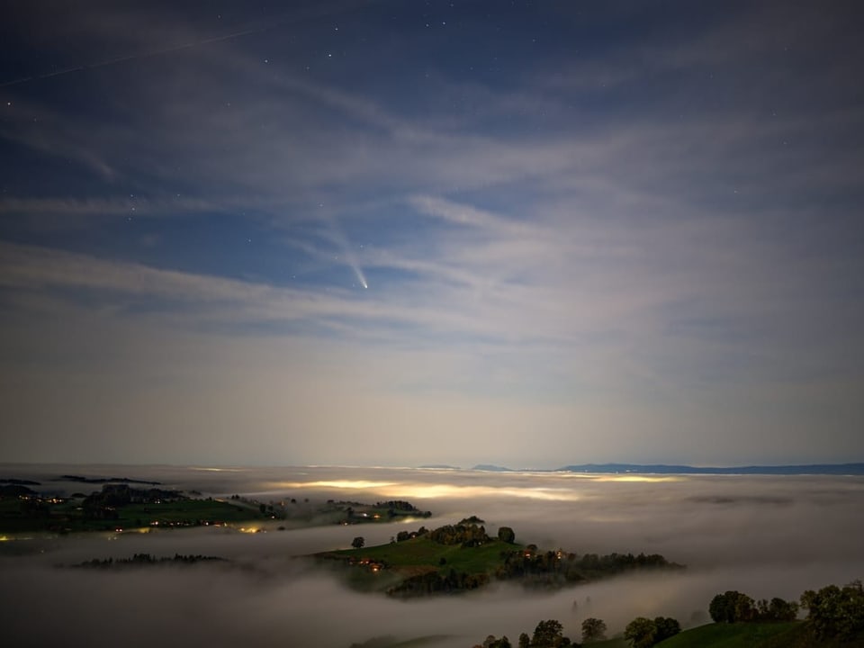 Nächtliche Landschaft mit Nebel und Sternenhimmel.