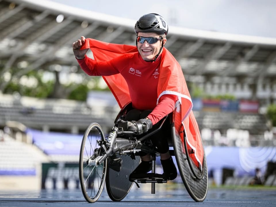 Glücklicher Rollstuhlfahrer in einem Stadion während eines Wettkampfs.