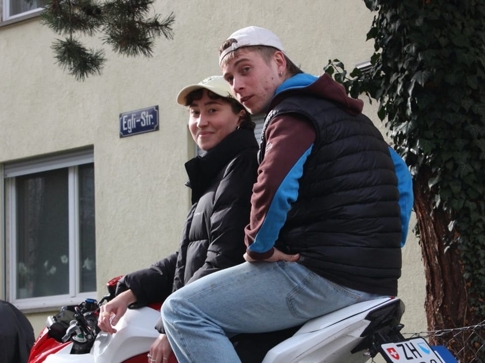 Zwei Personen auf einem Motorrad auf der Egli Strasse.